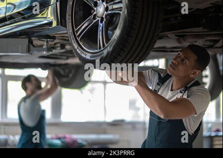 Team of auto mechanics fixing the customer vehicle Stock Photo