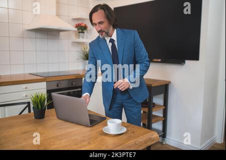 Man in elegant blue suit getting ready for online presentation Stock Photo