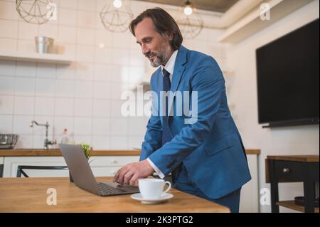 Man in elegant blue suit getting ready for online presentation Stock Photo