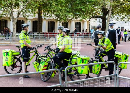 Four smartly uniformed st john ambulance operatives chat on the Mall in Central London preparing to help members of the public needing medical help Stock Photo