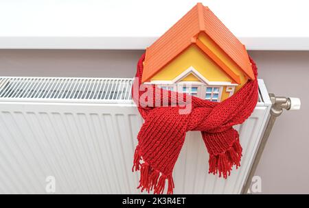 The house in the scarf stands on the radiator. Stock Photo