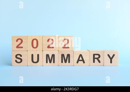 Year end 2022 review and summary concept. Wooden blocks in blue background. Stock Photo