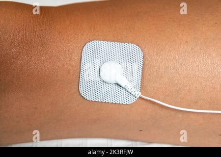 Self Adhesive Electrode Pad of TENS (transcutaneous electrical nerve stimulation) and EMS (electronic muscle stimulation) Unit Therapy Machine Stock Photo