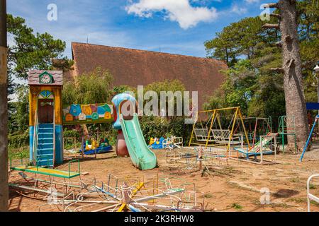 Old abandoned colorful playground in backyard with slide stands, swing, roundabout Stock Photo