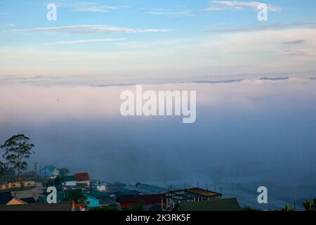 Town covered in the sea of clouds in the early morning in Da Lat city, Lam Dong, Viet Nam Stock Photo