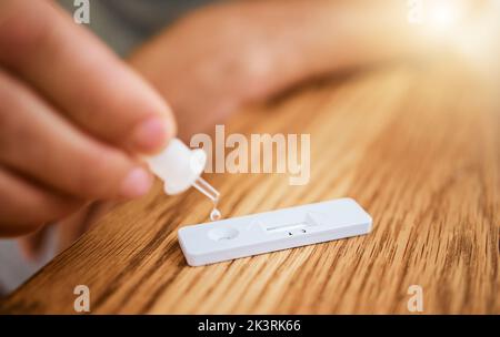 Hand, corona and covid home test for virus, disease and illness during lockdown inside. Zoom in of hands using medical tools for an antigen test for Stock Photo