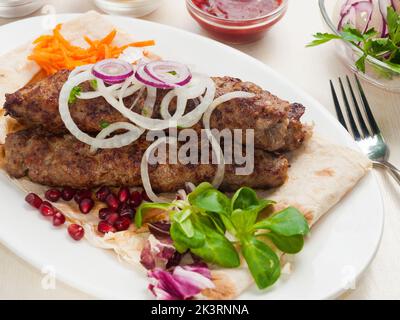 tasty Lula veal kebab pita bread with onions carrots and pomegranate seeds Stock Photo