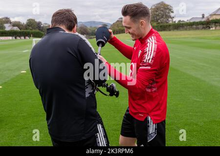 PONTYCLUN, WALES - 19 SEPTEMBER 2022: Wales' Connor Roberts and FAW TV Videographer Nathan Williamsduring a training session at the vale resort ahead Stock Photo