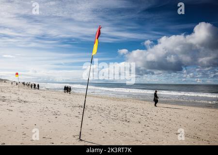 28 September 2022, Schleswig-Holstein, Westerland/Sylt: Walkers go for a stroll on Brandenburg beach in the sunshine. Photo: Frank Molter/dpa Stock Photo
