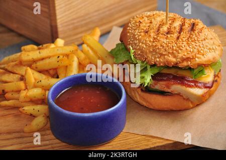 tasty Burger with chicken fillet, tomato sauce and potatoes Stock Photo