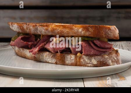 ciabatta sandwich with beef, cucumber and mustard sauce. End view. Close up Stock Photo