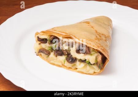 crepes with potatoes and mushrooms on a white plate Stock Photo