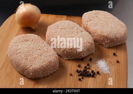 tasty raw chicken cutlets in breadcrumbs on a wooden Board Stock Photo