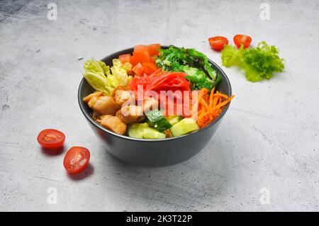 tasty poke with chicken and vegetables in a deep dish on a light background Stock Photo