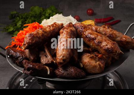 tasty Kazan kebab-assorted meat, heated on the fire. Traditional Asian dish Stock Photo