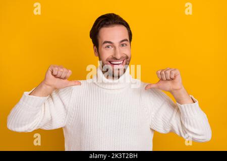Photo of charismatic bearded guy direct thumbs himself boasting wear white sweater isolated yellow color background Stock Photo