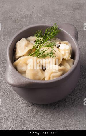 tasty dumplings in a pot in broth with butter and black pepper Stock Photo