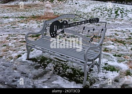River Reeves Viola Beach bench with guitar and music motif, Grappenhall Heys, Warrington, Cheshire,England, UK in winter snow 2020 Stock Photo