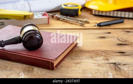 Construction and Labor law. Judge gavel and engineering tools on wooden table, close up view. Stock Photo