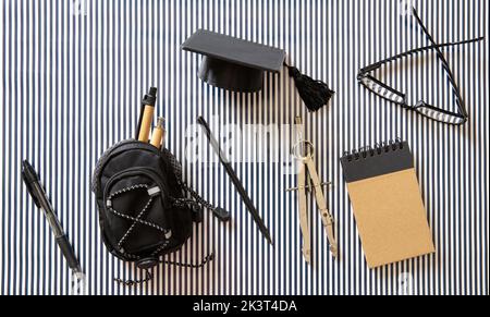 University, school accessories. College graduation cap and student stationery on black white background. Top view Stock Photo