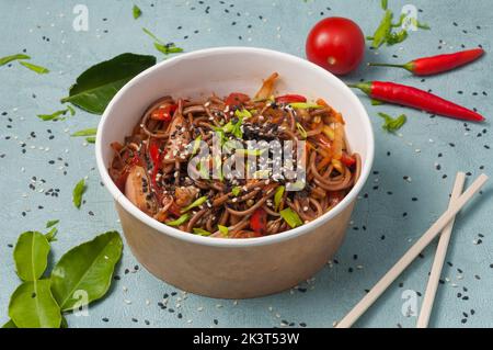 tasty buckwheat noodles with chicken and vegetables in a craft bowl Stock Photo