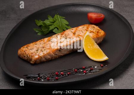 tasty grilled salmon steak on a dark plate Stock Photo