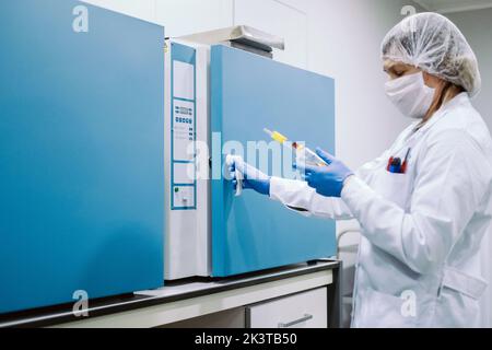Portrait of scientist wearing gloves, mask and cap working in lab Stock Photo