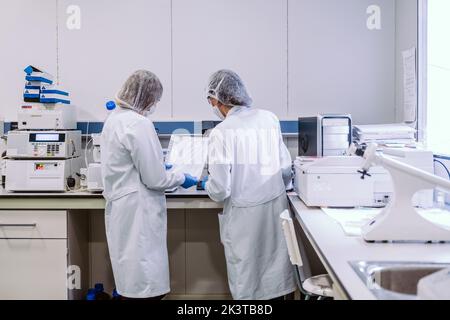 Young women standing with papers and in laboratory. Stock Photo