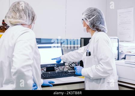 Rear view of two young doctors at computer in laboratory Stock Photo