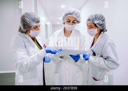 Young women standing with papers in laboratory. Stock Photo