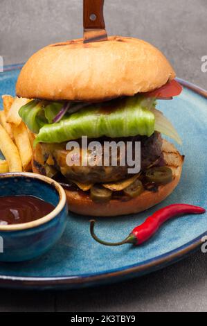 tasty burger with beef patty, cheddar cheese, nachos and jalapeno Stock Photo