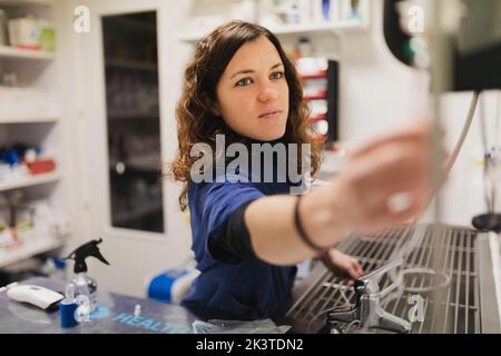 Young female doctor in uniform using medical equipments medical casein room on blurred background Stock Photo