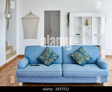 Comfortable blue couch with cushions placed in spacious living room of house in modern style Stock Photo