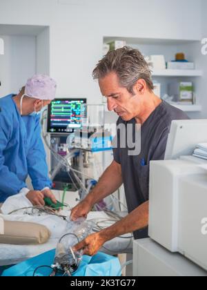 Doctors preparing operating theater for surgery while working in modern hospital together Stock Photo