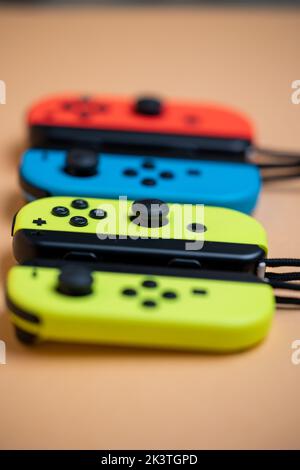Nintendo Switch Joy-Cons aligned in a row. Yellow blue and red Joy-Cons. Yellow Joy-Con in Focus Stock Photo