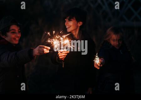 Group of young preteen friends playing with sparkles on forest Stock Photo