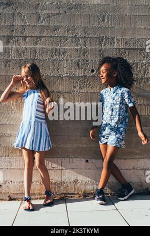 Laughing multiracial children grimacing and smiling in bright sunny day Stock Photo