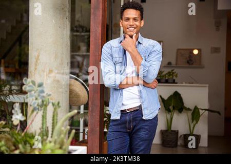 Latin American plant nursery owner with hand on chin looking at the camera Stock Photo