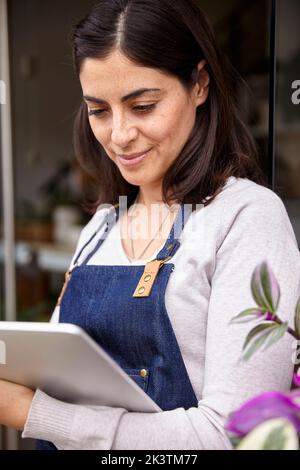 Garden center female owner using digital tablet Stock Photo