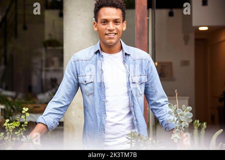 Smiling Latin American nursery plant worker standing outdoors Stock Photo