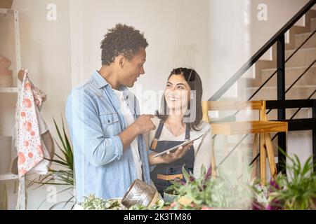 Greenhouse workers discussing over digital tablet Stock Photo