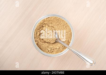 Top view of ground ginger root powder and a spoon in a jar. Copy space. Stock Photo