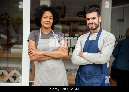 Bakery owners wearing apron standing with arms crossed Stock Photo