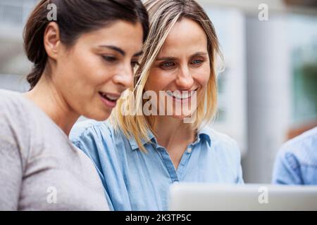 Small business coworkers sitting outdoor using laptop Stock Photo