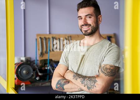 Mid-shot of confident looking bearded bicycle repair shop owner Stock Photo