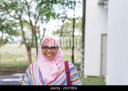 Islamic female in hijab walking near parking lot while commuting to work in Costa Rica Stock Photo