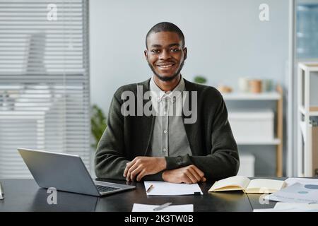 Front view portrait of young black man smiling at camera in job interview Stock Photo