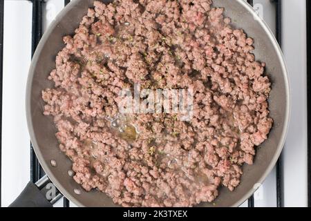 Top view of ground beef with condiments frying on pan for cooking lunch Stock Photo