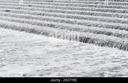 River Trent water flowing over steps in Beeston Rylands Weir creating bubbles and foam downstream Stock Photo