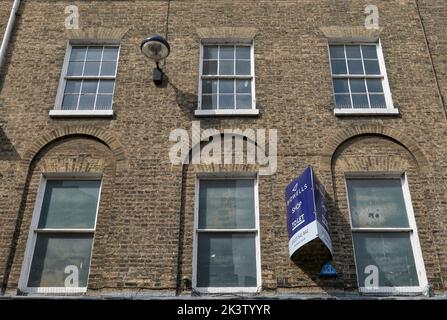 Upper floors of building above shop in 7 Market Street, Cambridge, showing brickwork in round and flat arches above windows. Stock Photo